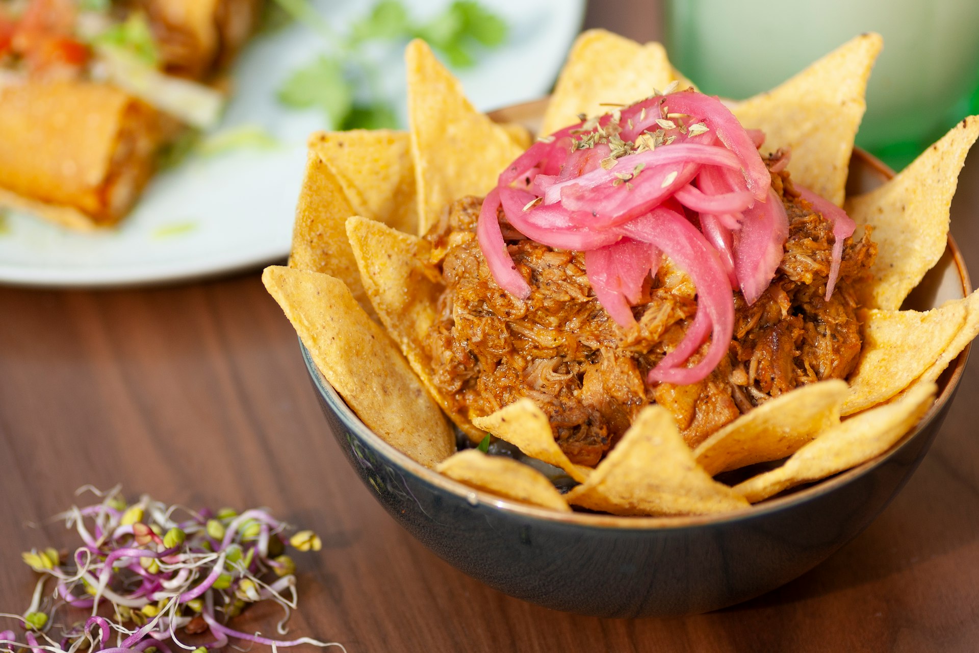 a bowl filled with tortilla chips topped with onions